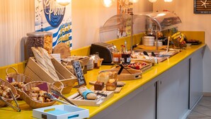 A breakfast buffet with various breads, pastries, and condiments. - The Originals City Hotel Hippocampe Sète Balaruc (Balaruc-le-Vieux)
