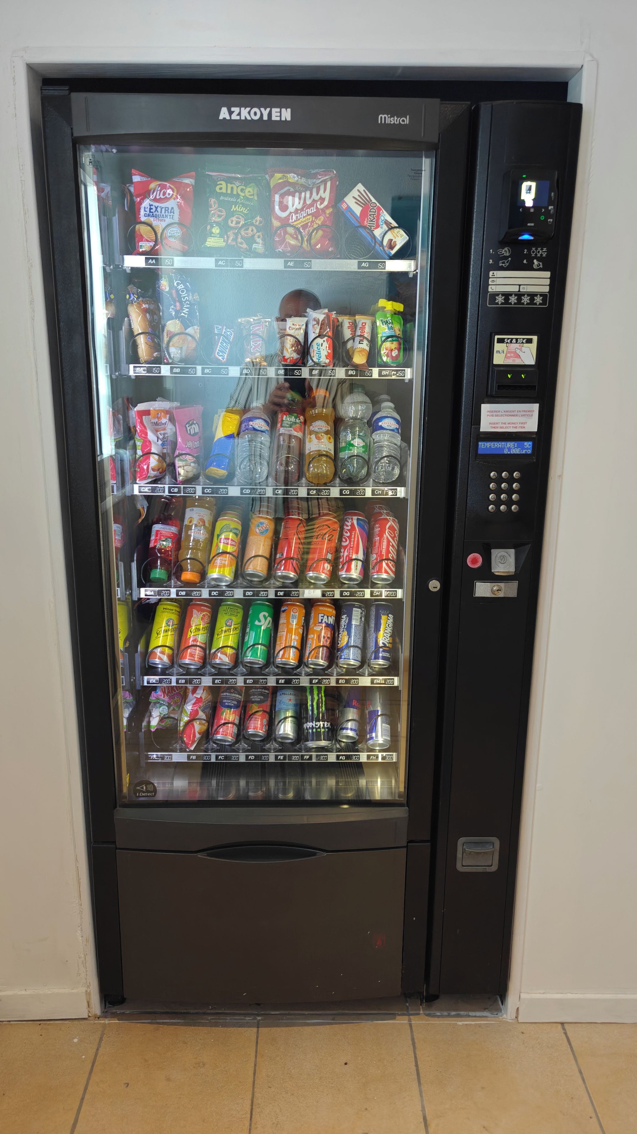 Un distributeur automatique proposant une variété de collations, de boissons et de produits rafraîchissants.