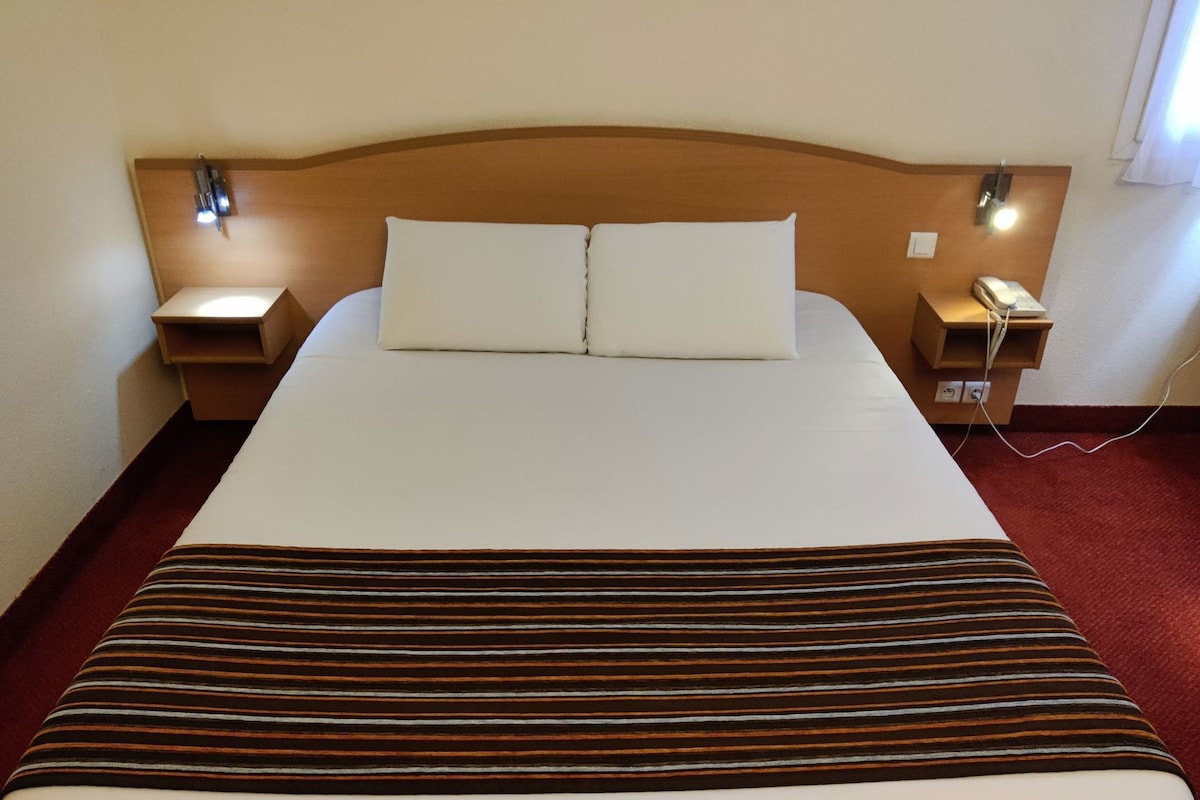 Premium bedding, desk, laptop workspace, blackout drapes