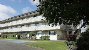 Ein mehrstöckiges Hotel mit schlichter Fassade, großen Fenstern und einem zentralen Eingang.