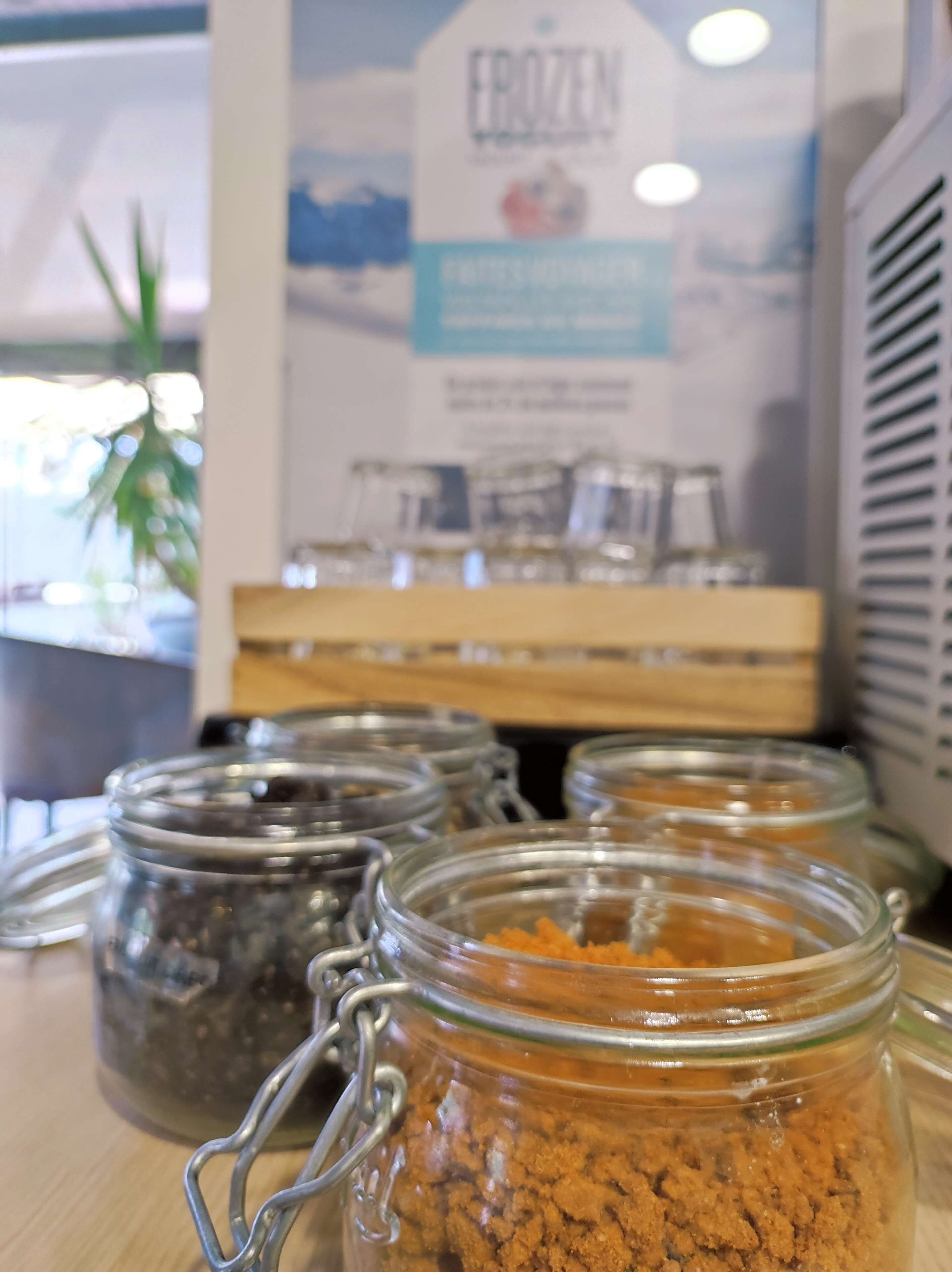 A display of jars with different contents, possibly spices or condiments, in a store or market setting.