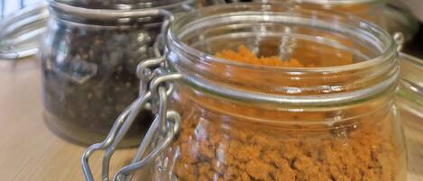 A display of jars with different contents, possibly spices or condiments, in a store or market setting.
