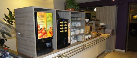 A self-service breakfast station with a coffee machine, a juice dispenser, and a sign advertising tropical orange juice.