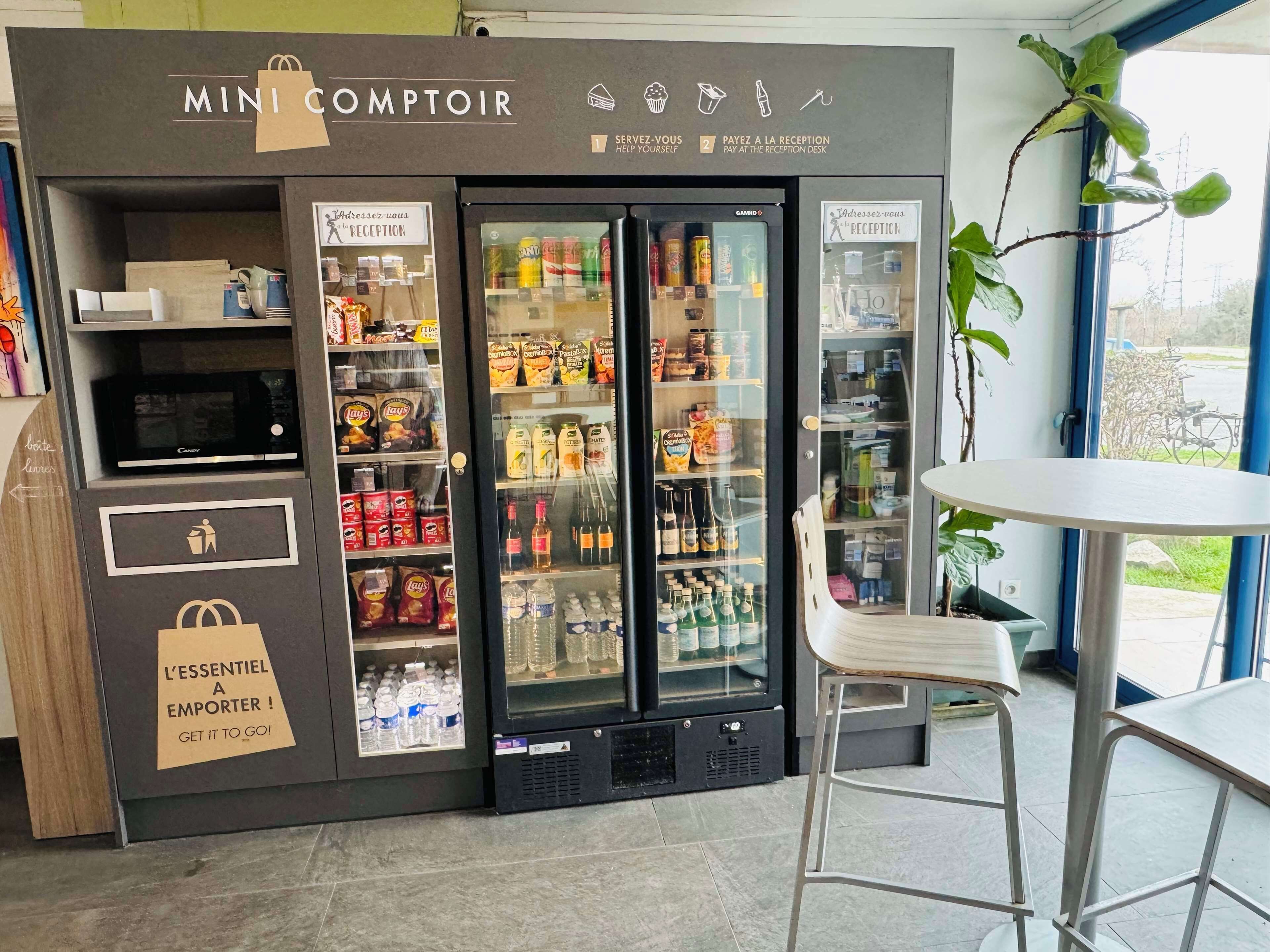 A Mini Comptoir with a self-service kiosk, refrigerated display cases, and a reception desk.