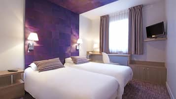 Une chambre d’hôtel avec deux lits, un bureau, une télévision et une fenêtre avec des rideaux.