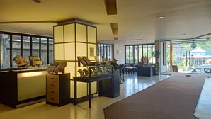 Un vestíbulo amplio con mostrador de recepción, zona de estar y grandes ventanales que ofrecen luz natural.