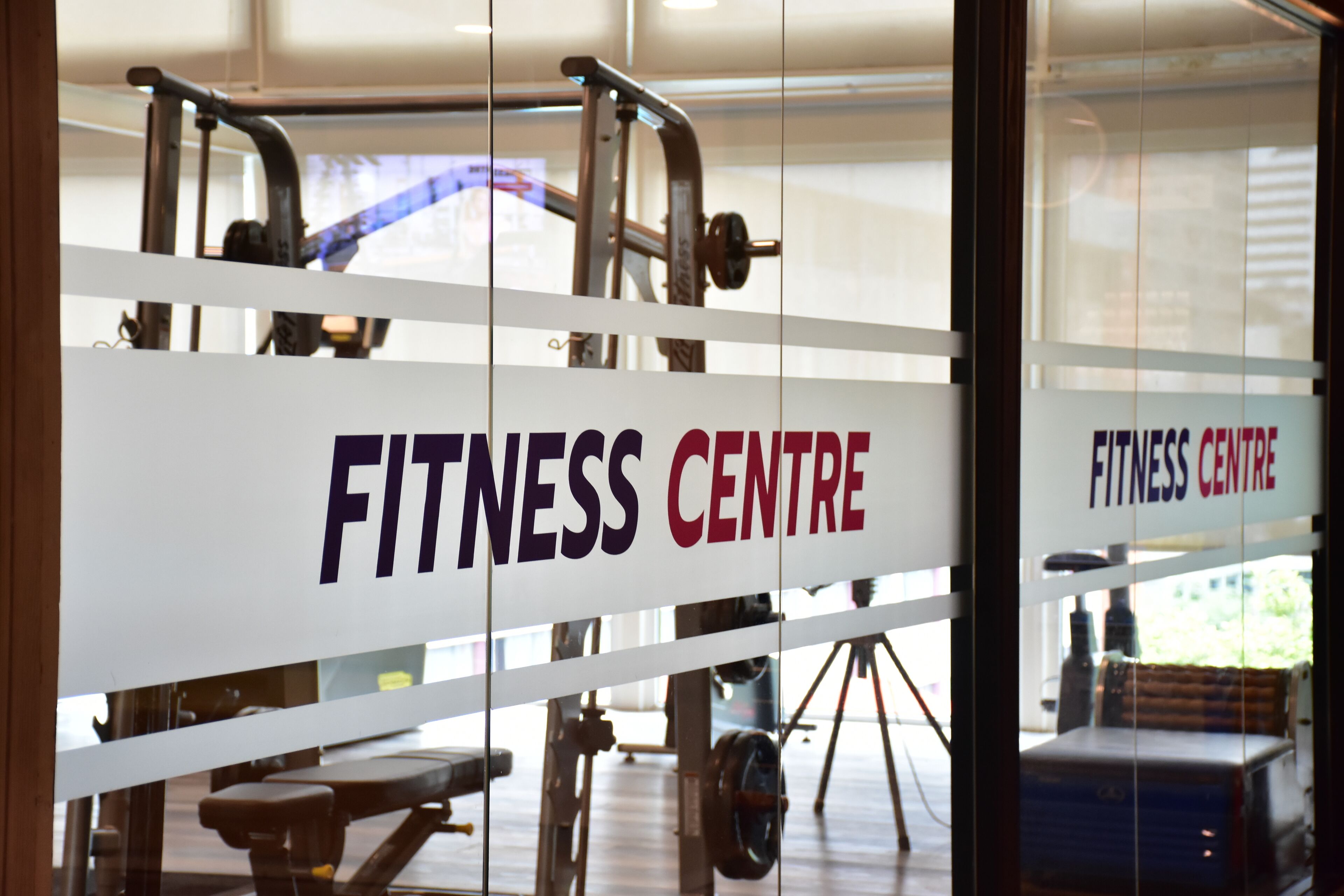 Un gimnasio con equipo de ejercicio y un cartel que dice 'FITNESS CENTRE'.