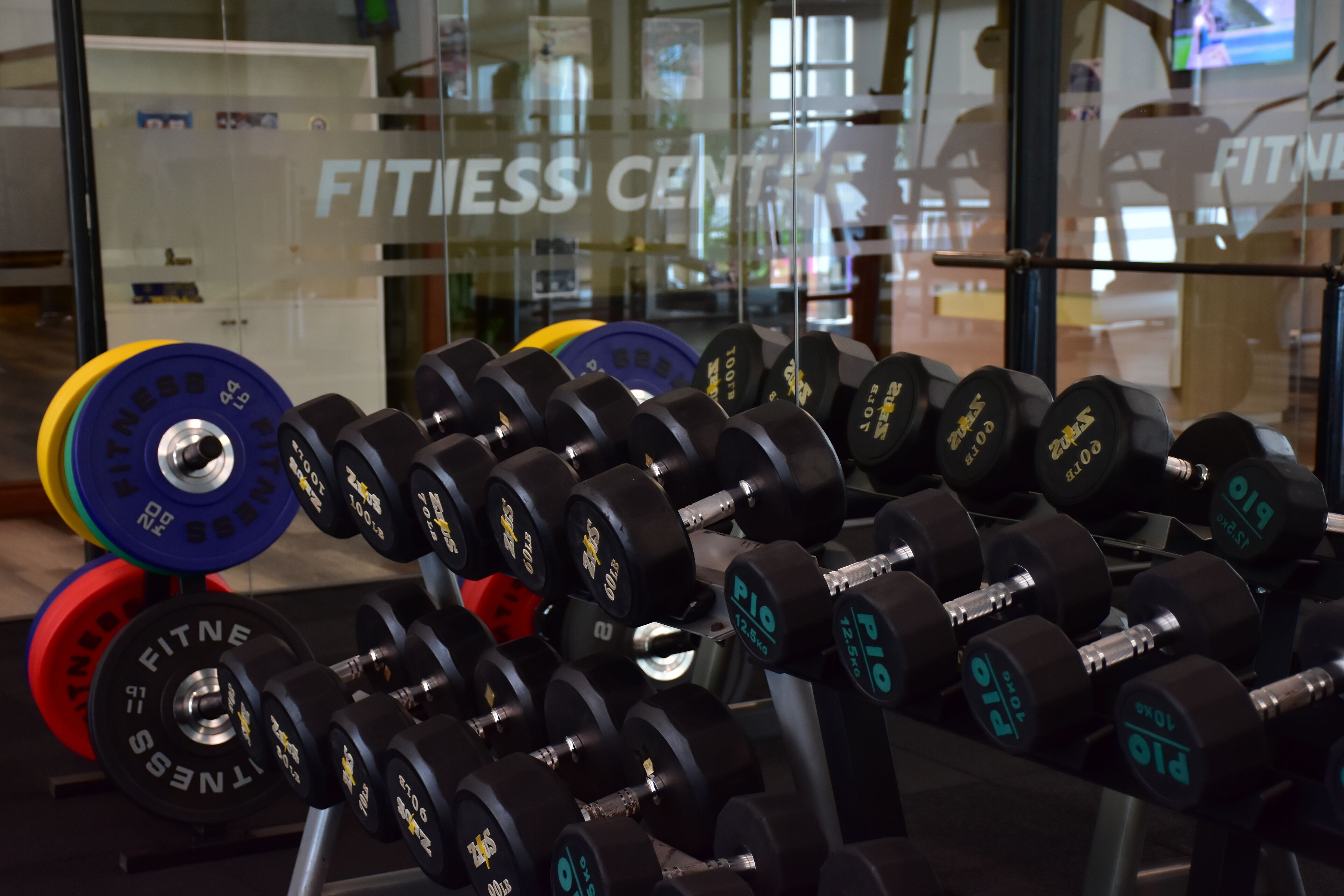 A gym with rows of dumbbells and weight plates.