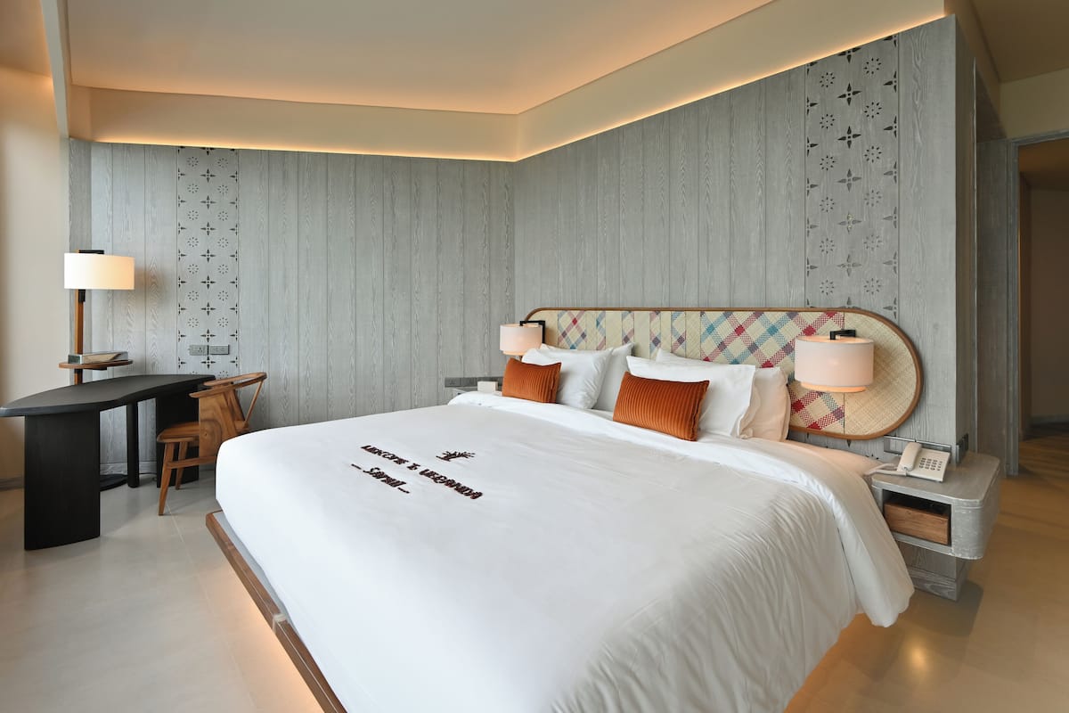 Une chambre d’hôtel moderne avec un grand lit, un bureau et une chaise.