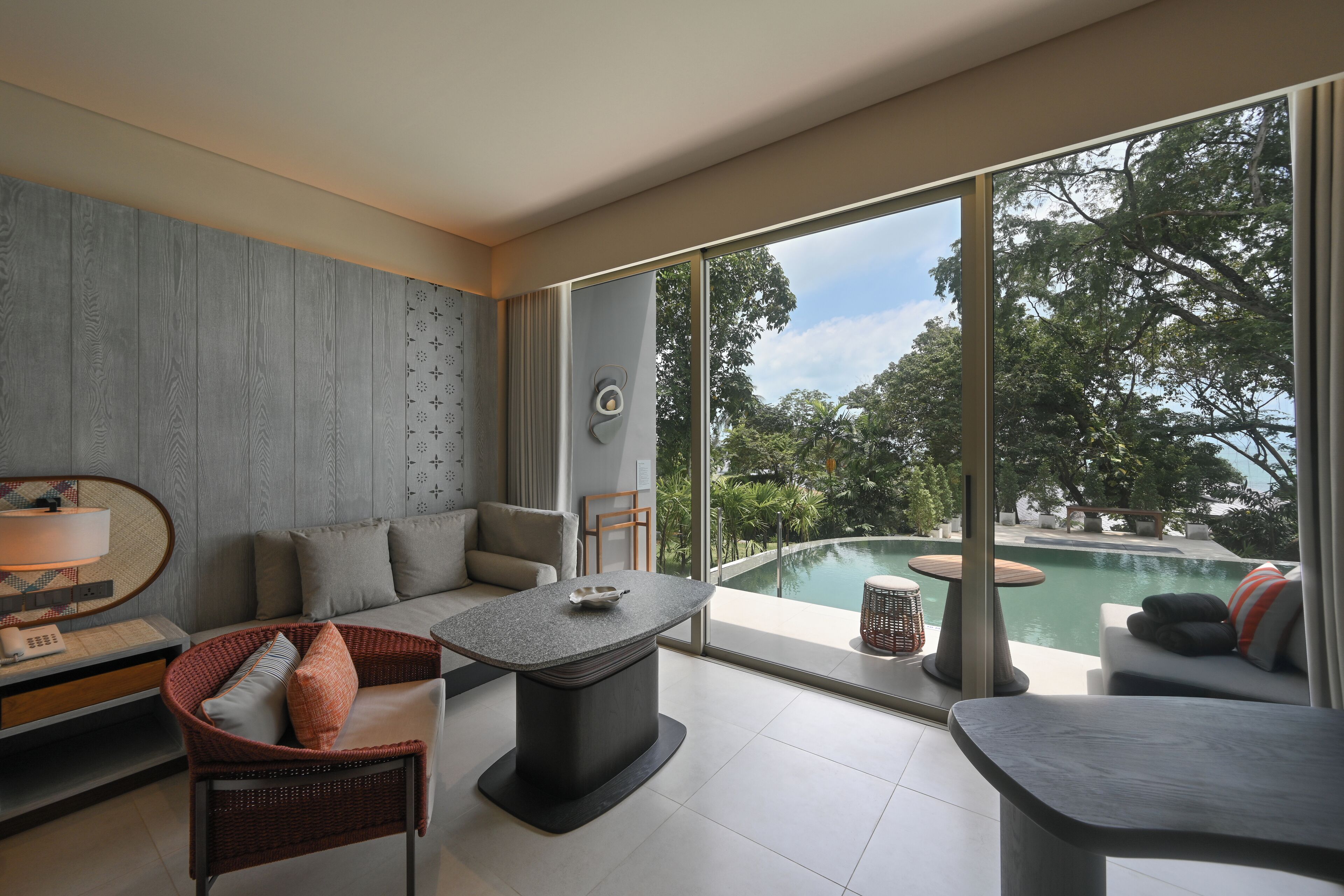Ein modernes Wohnzimmer mit großem Fenster, Schwimmbad und einer Couch.