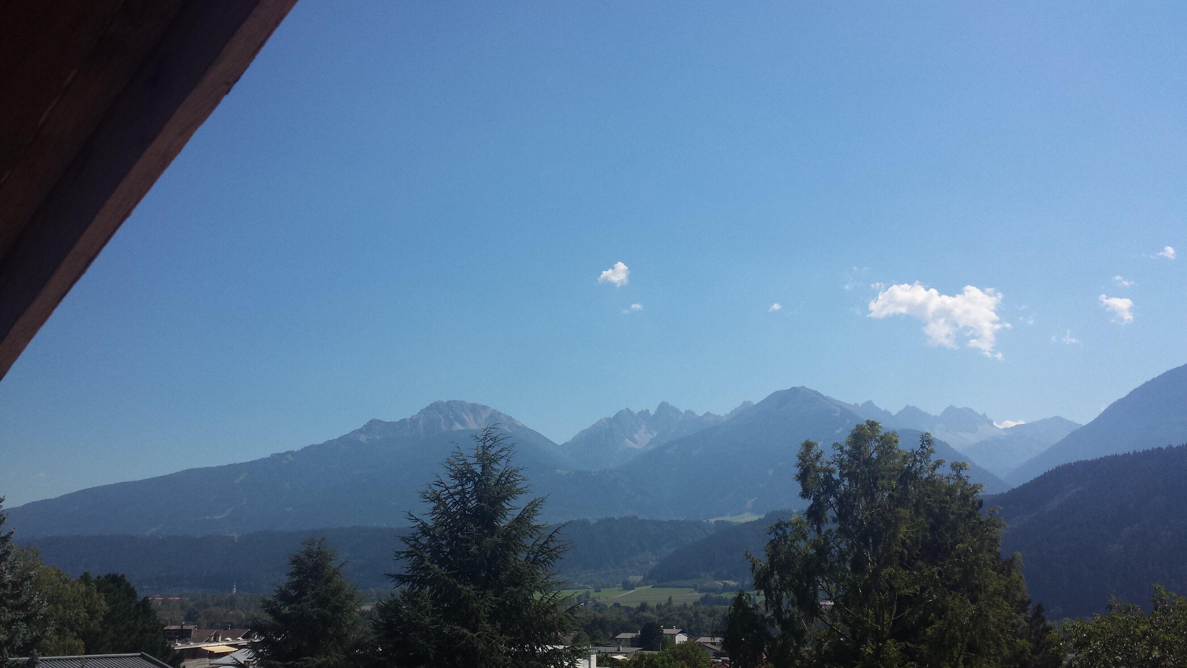 Un paysage de montagne avec un ciel dégagé et des sommets lointains.
