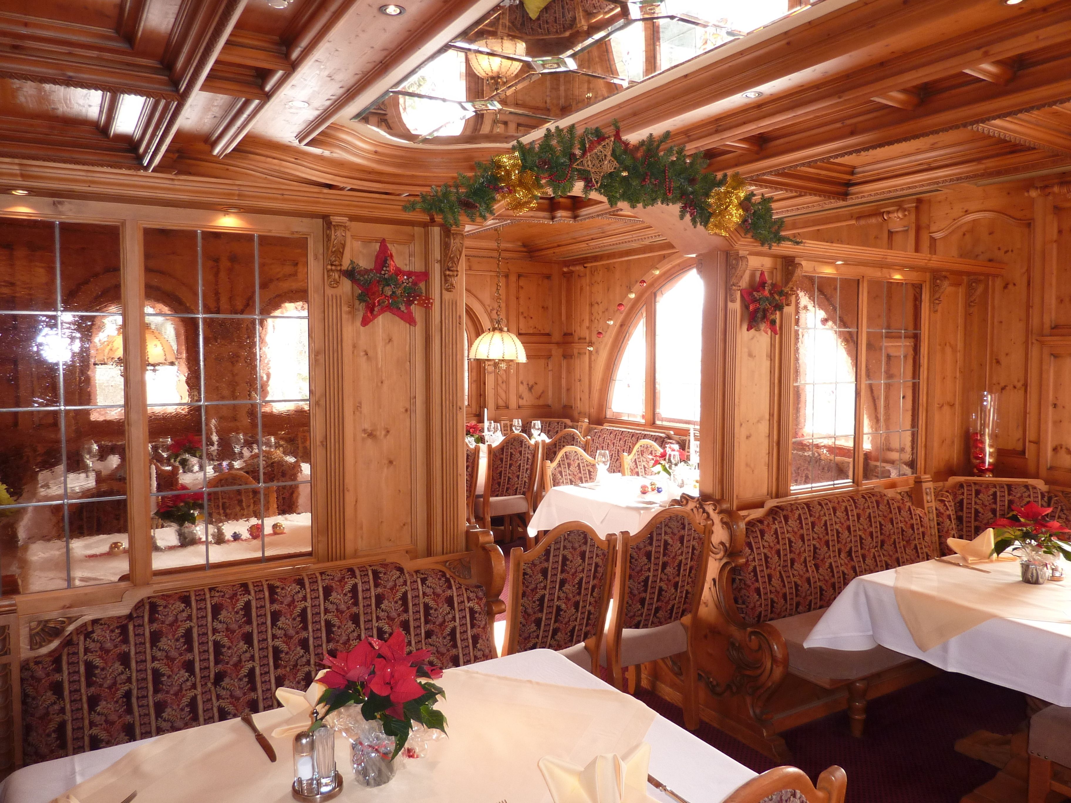 A cozy restaurant with wooden interiors, large windows, and festive decorations.