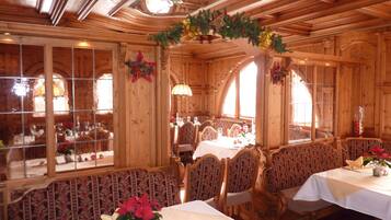 A cozy restaurant with wooden interiors, large windows, and festive decorations.