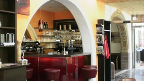 A bar area with stools, a counter, and shelves with bottles. - Hotel Tyrolis (Zirl)