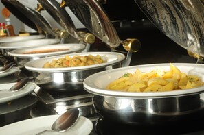 A buffet setup with multiple serving dishes containing various foods. - Jacaranda Indian Ocean Beach Resort (Diani Beach)