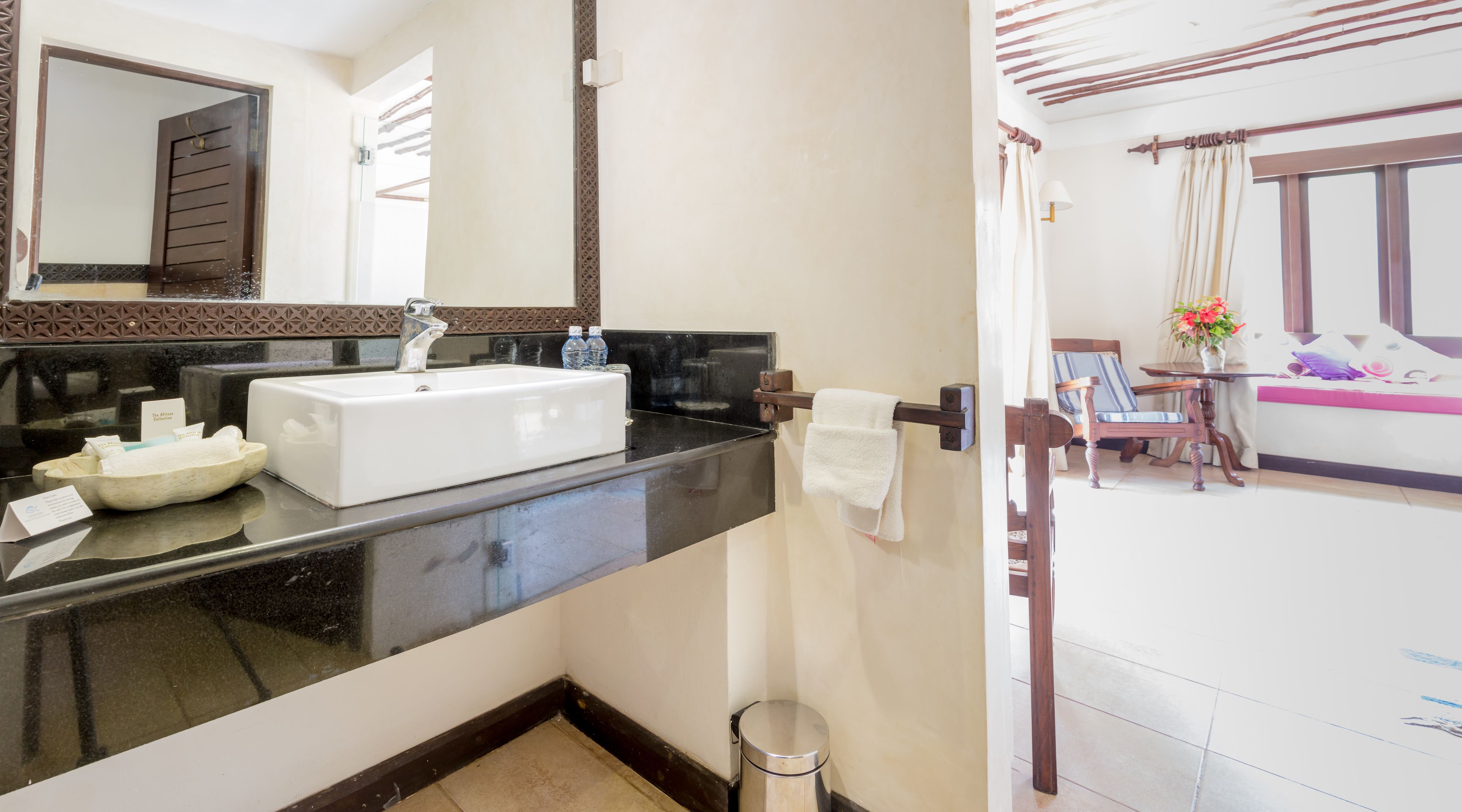 A bathroom with a white sink, a mirror, and a towel rack.