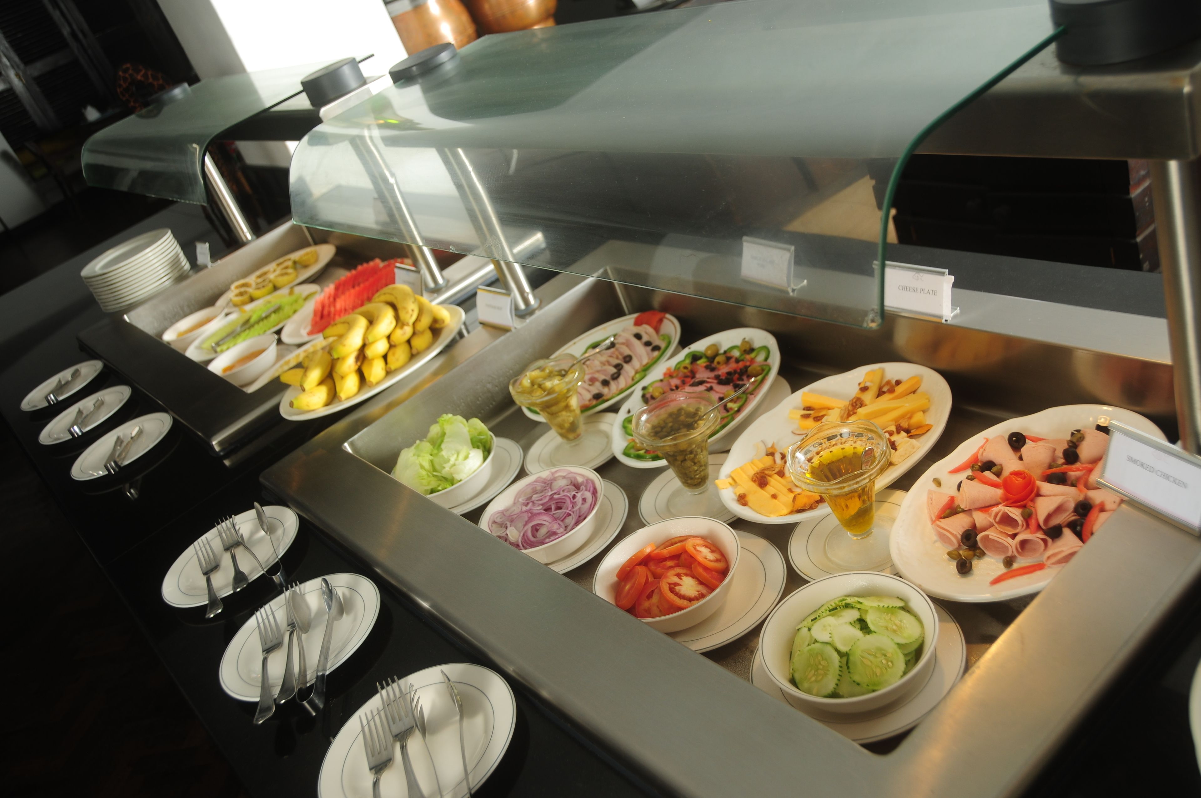 A buffet with various food items and utensils.