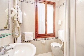 A bathroom with a sink, toilet, and hairdryer. - Hotel Atlantide (Venice)