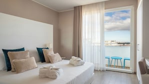 A hotel room with a bed, pillows, a towel, a balcony with a view, and a table. - Hotel Biancamano (Rimini)