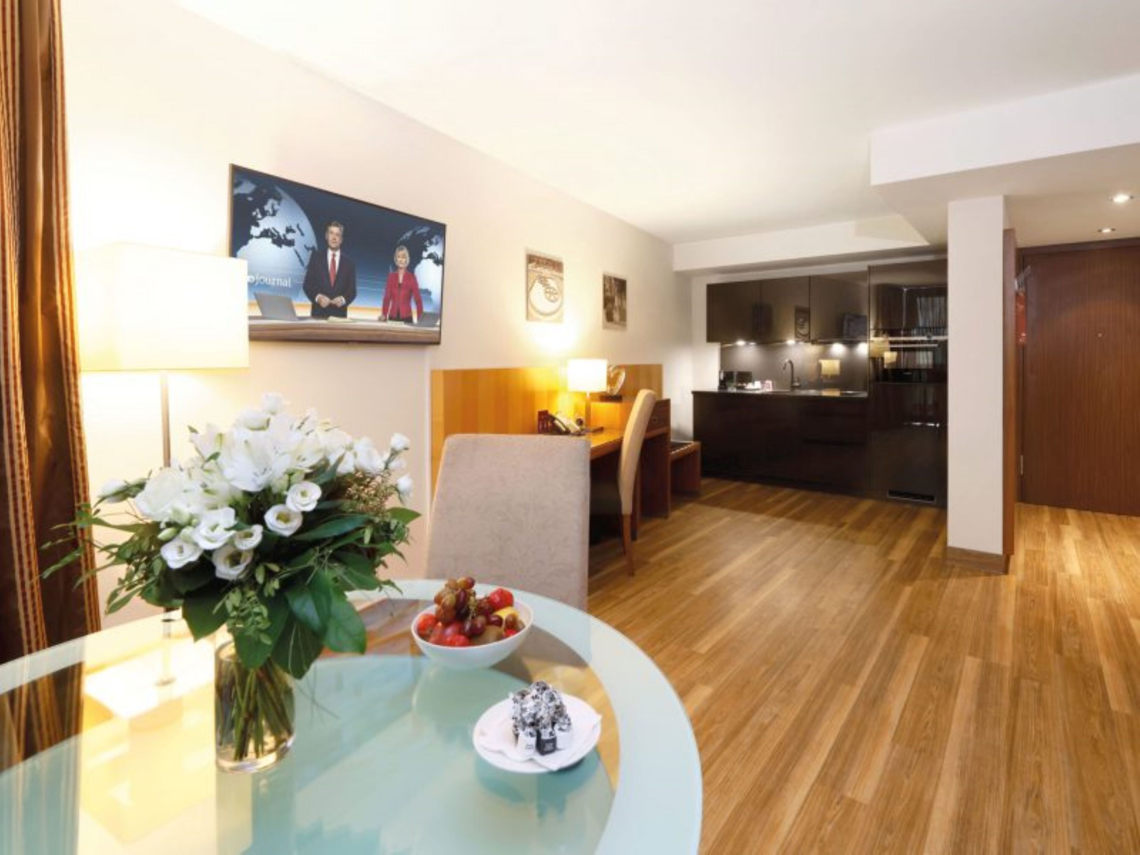 Una habitación de hotel moderna con comedor, cocina y sala de estar.