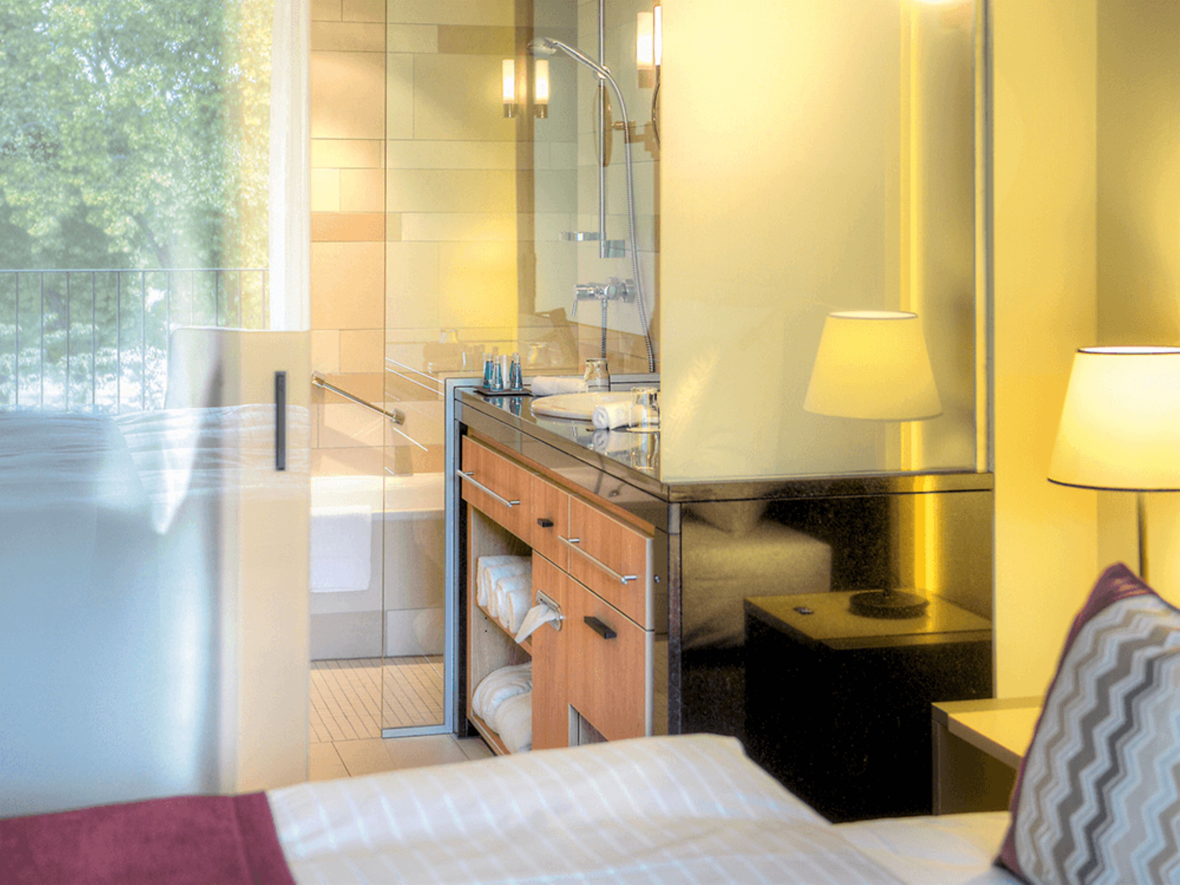 A modern bathroom with a glass shower enclosure, a wooden vanity, and a large mirror.