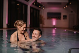 Una piscina techada, sillones reclinables de piscina