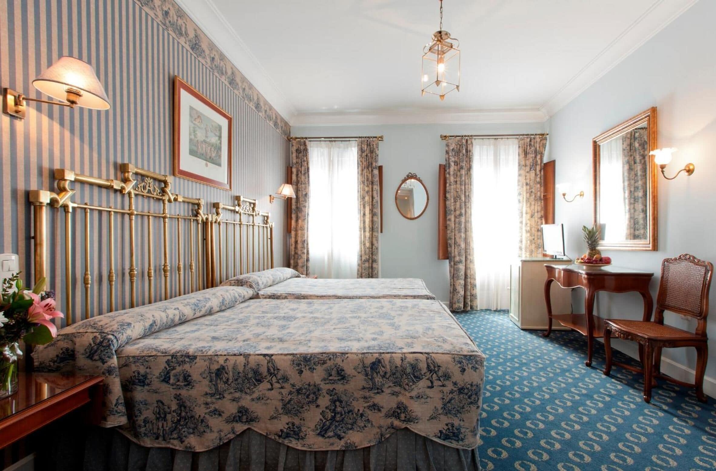 Una habitación de hotel con una cama grande, un escritorio, una silla y un espejo.