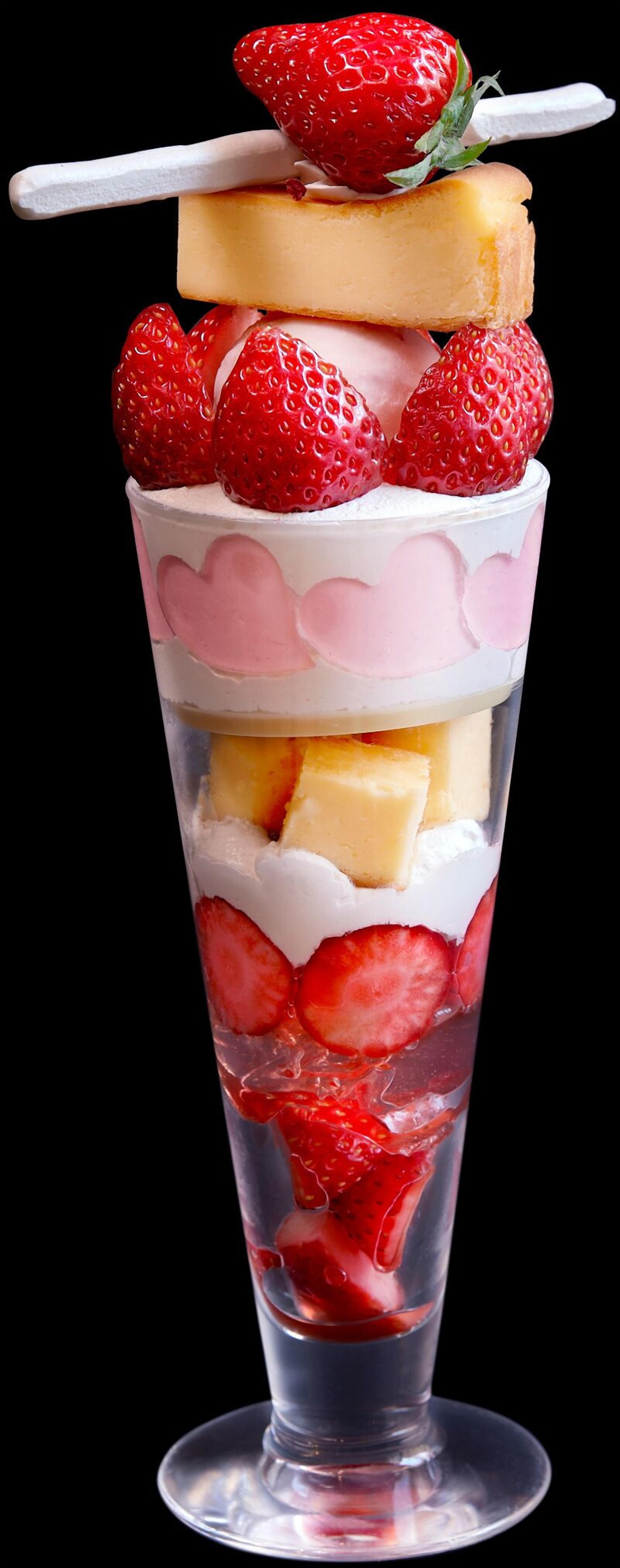 Un postre en capas con fresas y una banana encima.