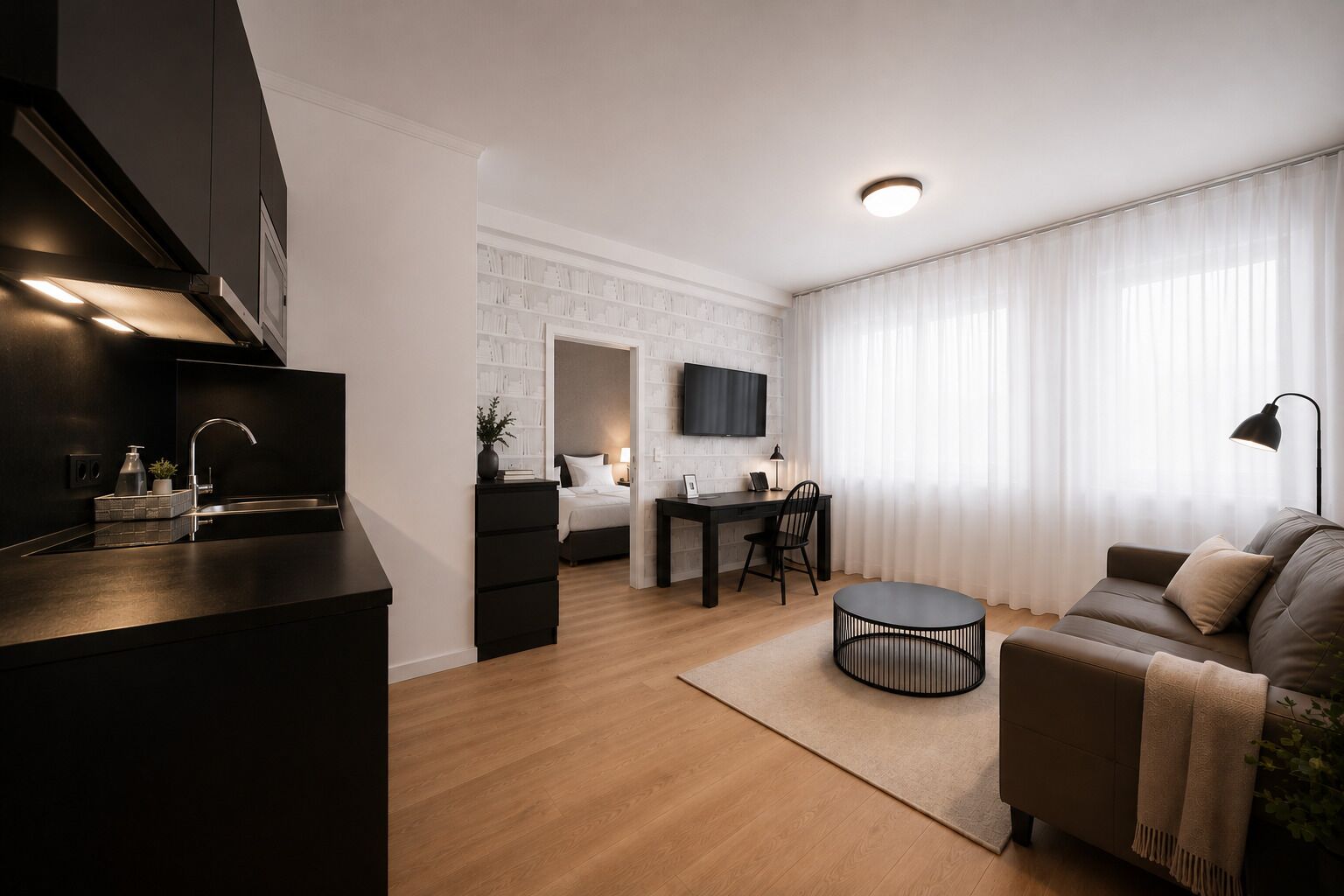 Un apartamento moderno con cocina, comedor y sala de estar, que cuenta con una televisión de pantalla plana, un sofá y una mesa redonda.