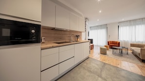 Een moderne keuken met een Bosch magnetron, witte kastjes en een houten aanrecht.