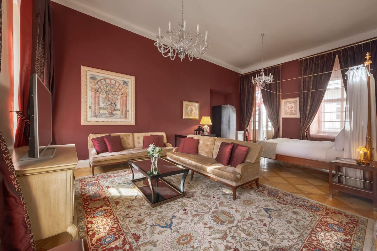 A well-furnished living room with a sofa, a coffee table, a TV, and a chandelier.