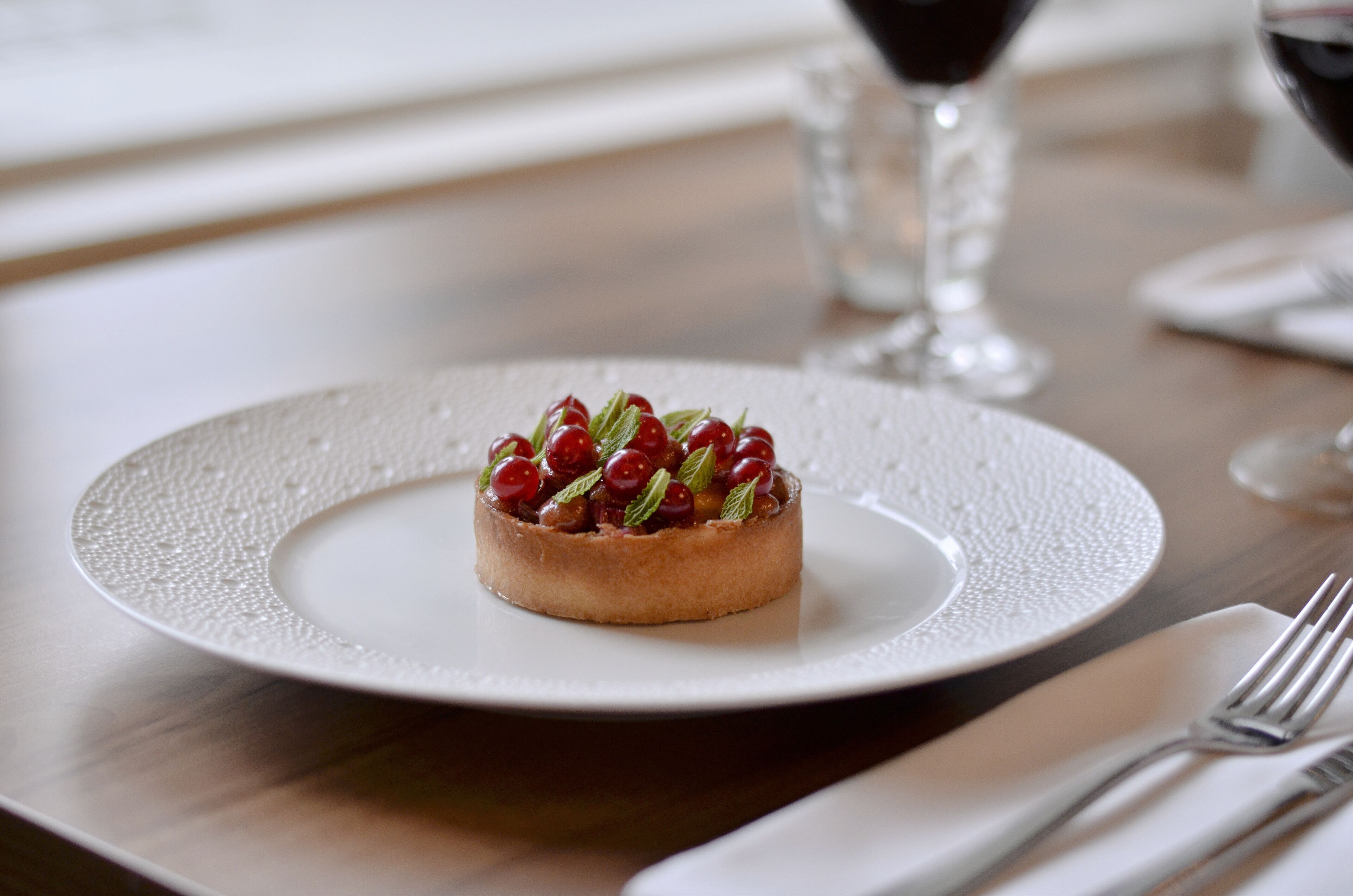 Postre sobre un plat blanc amb vora rugosa, damunt d'una taula de fusta.