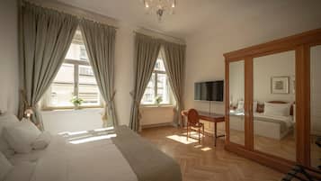 Quarto com uma cama grande, uma escrivaninha e um guarda-roupa.