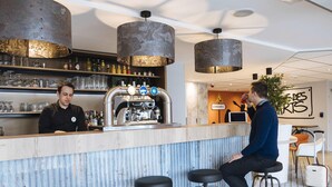 A bar area with a counter, stools, and a coffee machine. - ibis Styles Lille Marcq en Baroeul (Marcq-en-Baroeul)