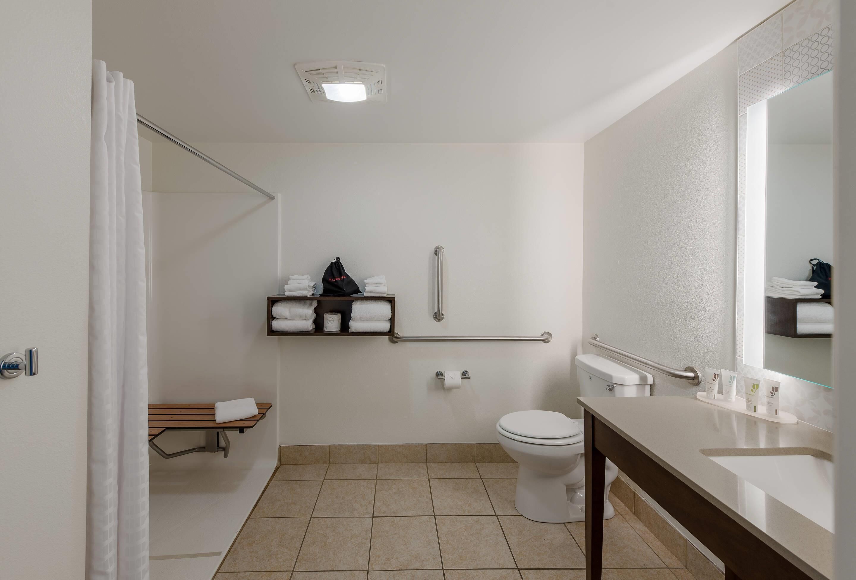 A modern bathroom with a toilet, sink, and shower area.