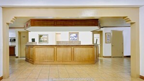 Una cocina amplia con una isla central, armarios de madera y piso de baldosas.
