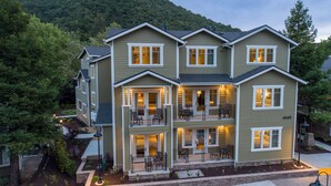 A multi-story residential building with a balcony on the second floor, a driveway, and a landscaped front yard. - Avila Village Inn (Avila Beach)