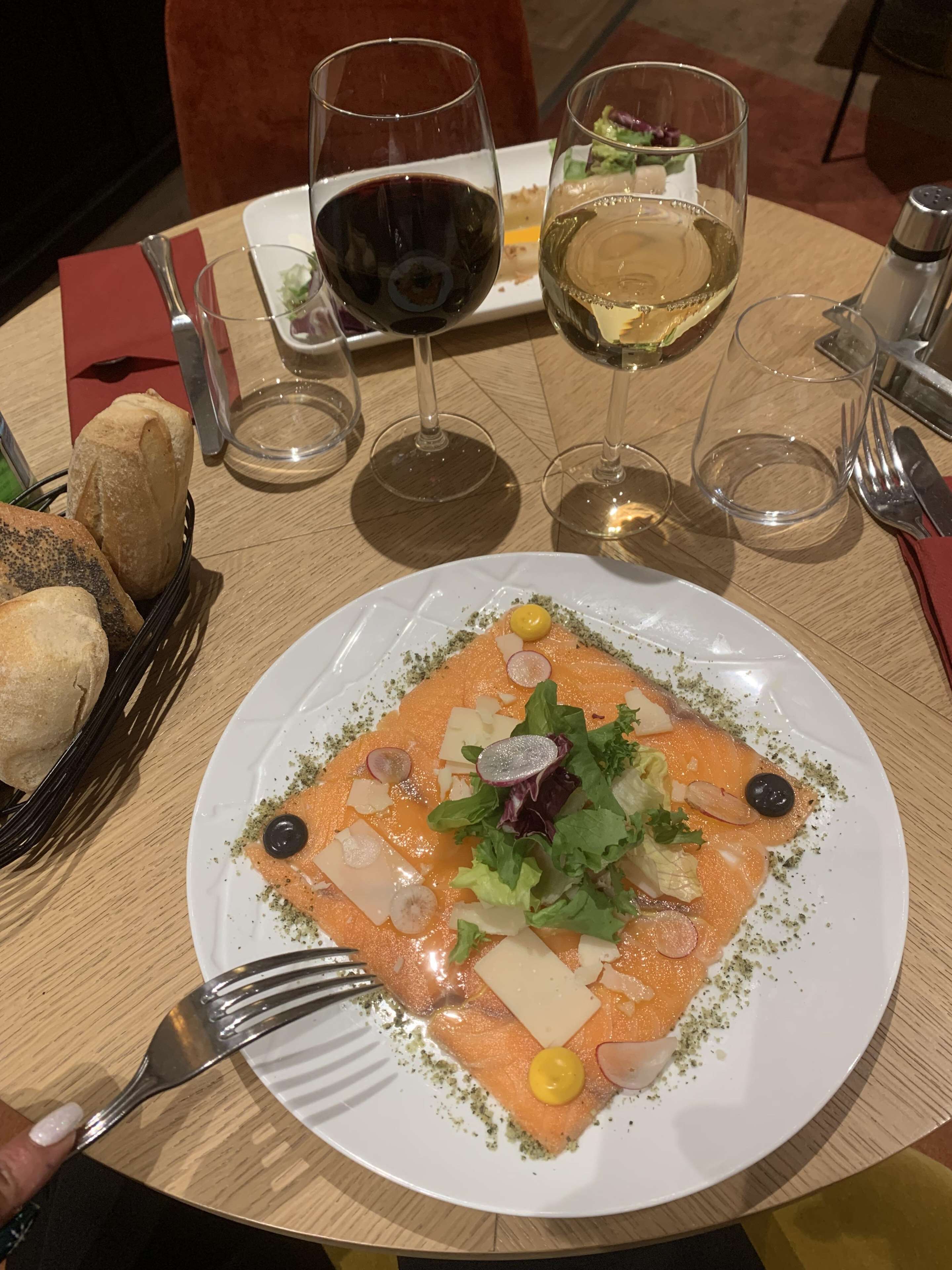 Et spisebord med mad, vinglas og brød.