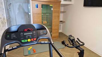 A home gym with a stationary bike, a treadmill, and a weight bench.