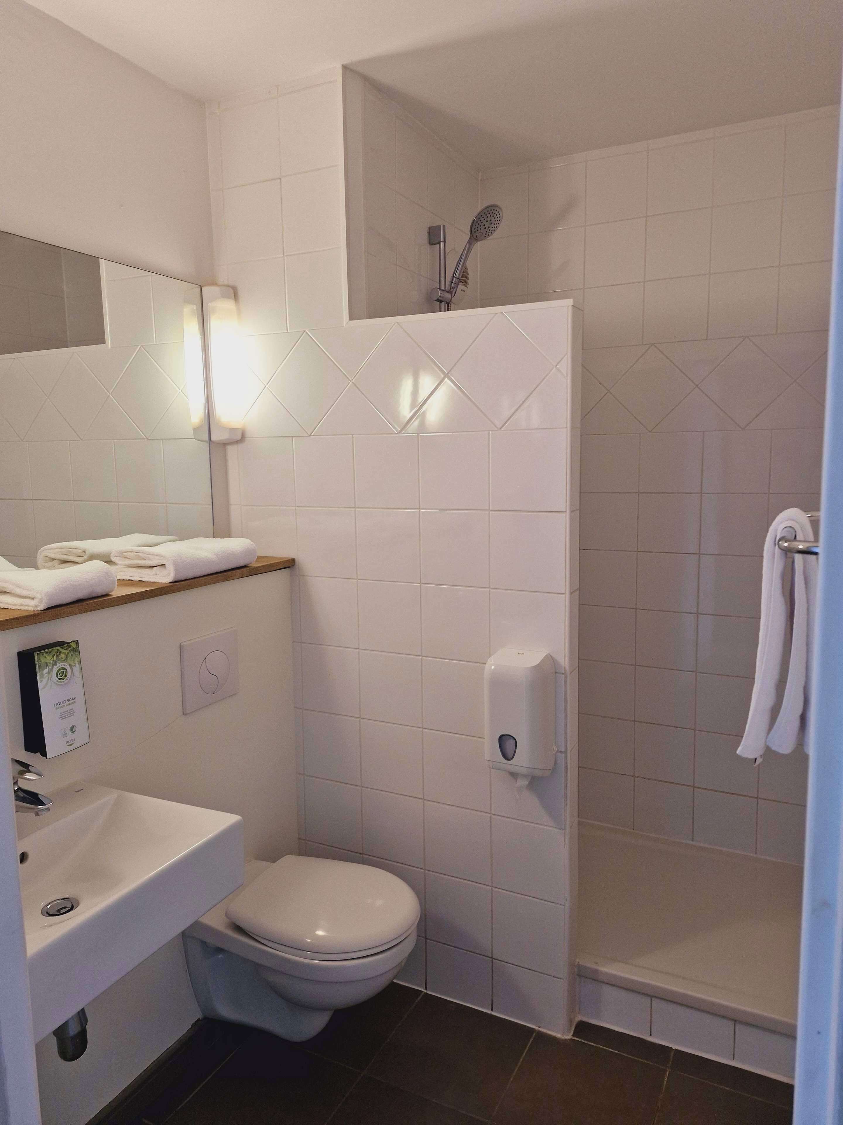 A bathroom with a toilet, sink, and shower.