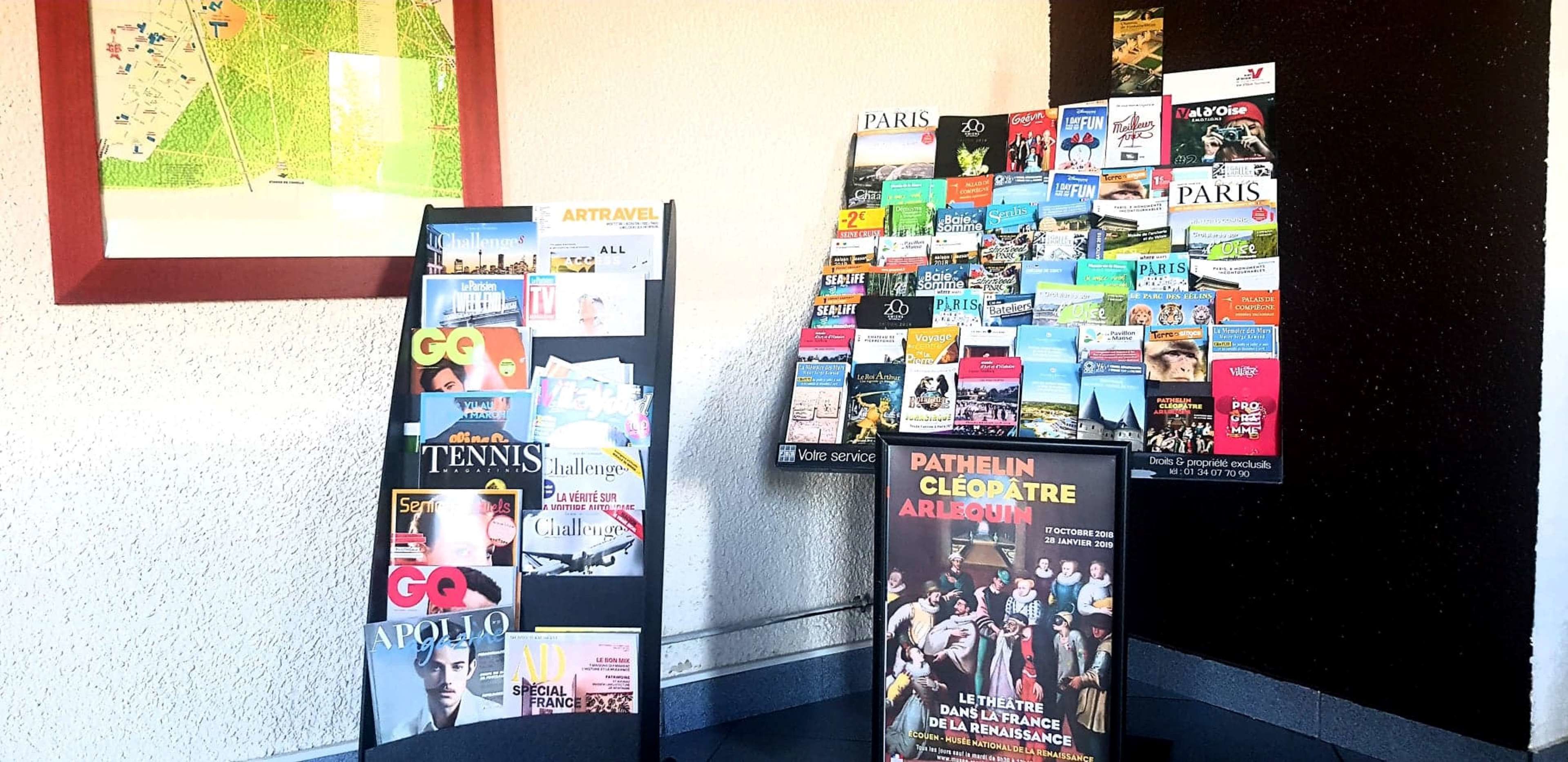 A wall with various posters and magazines, including titles like 'PARIS', 'TENNIS', and 'GO'.
