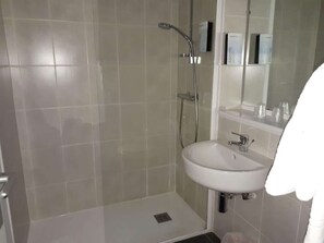 A bathroom with a shower, a sink, and a mirror. - Campanile Sable Sur Sarthe (Vion)