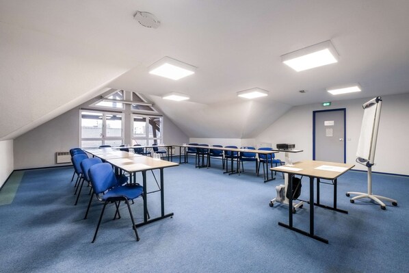 A conference room with blue chairs, tables, and a whiteboard. - Comfort Hotel Lille Lomme (Lille)