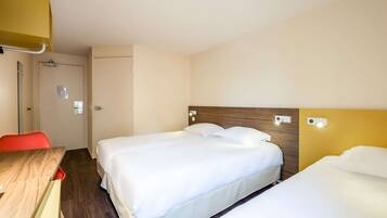 A hotel room with two beds, a wooden desk, a red chair, and a door.