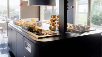 Een moderne keuken met een centraal eiland, grote ramen en een hanglamp.