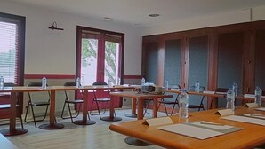A conference room with long tables, chairs, nameplates, water bottles, and a projector. - Hôtel Inn Design Laval  (Laval)