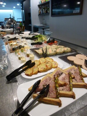 A buffet with various dishes including bread, meat, and salads.