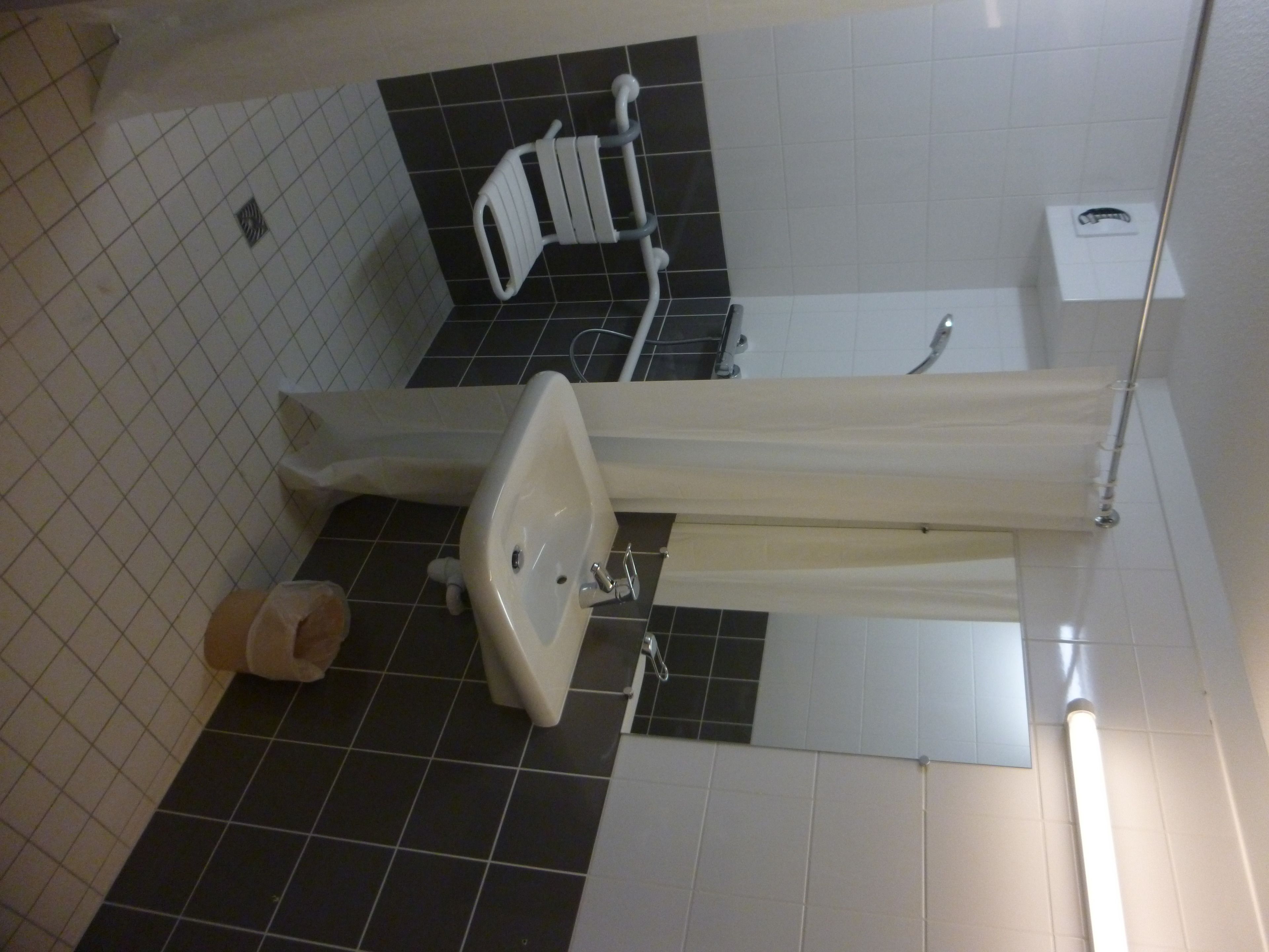 A bathroom with a white sink, a toilet, and a shower area.