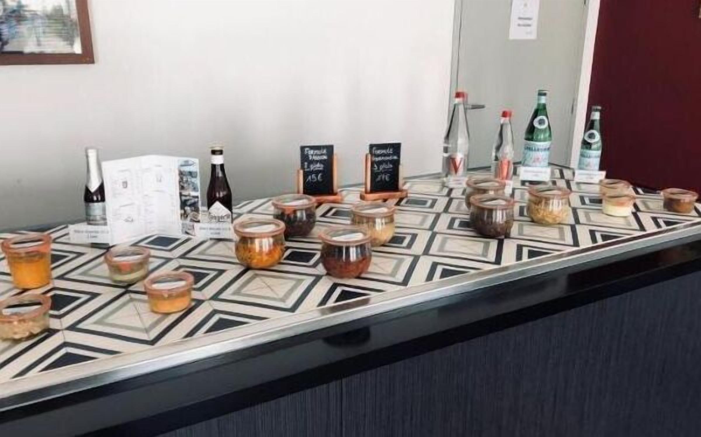 Un espace bar avec différentes bouteilles et bocaux contenant des boissons, dont certaines sont étiquetées avec les prix.