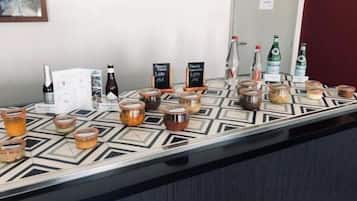 Una zona de bar con varias botellas y frascos de bebidas, algunas con precios indicados.